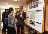 Two academics discuss research presented in a poster session