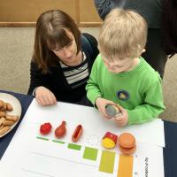 A child and his mother use plastic food in in our GHG game